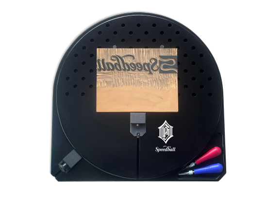 Top down view of black rotating bench hook with a carved block and two lino carving tools.